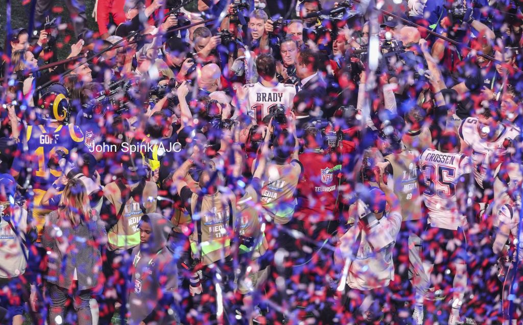 John Spink/Atlanta Journal-Constitution - Los Angeles Rams quarterback Jared Goff (left) tries to make his way to New England Patriots quarterback Tom Brady (right) in a shower of confetti.