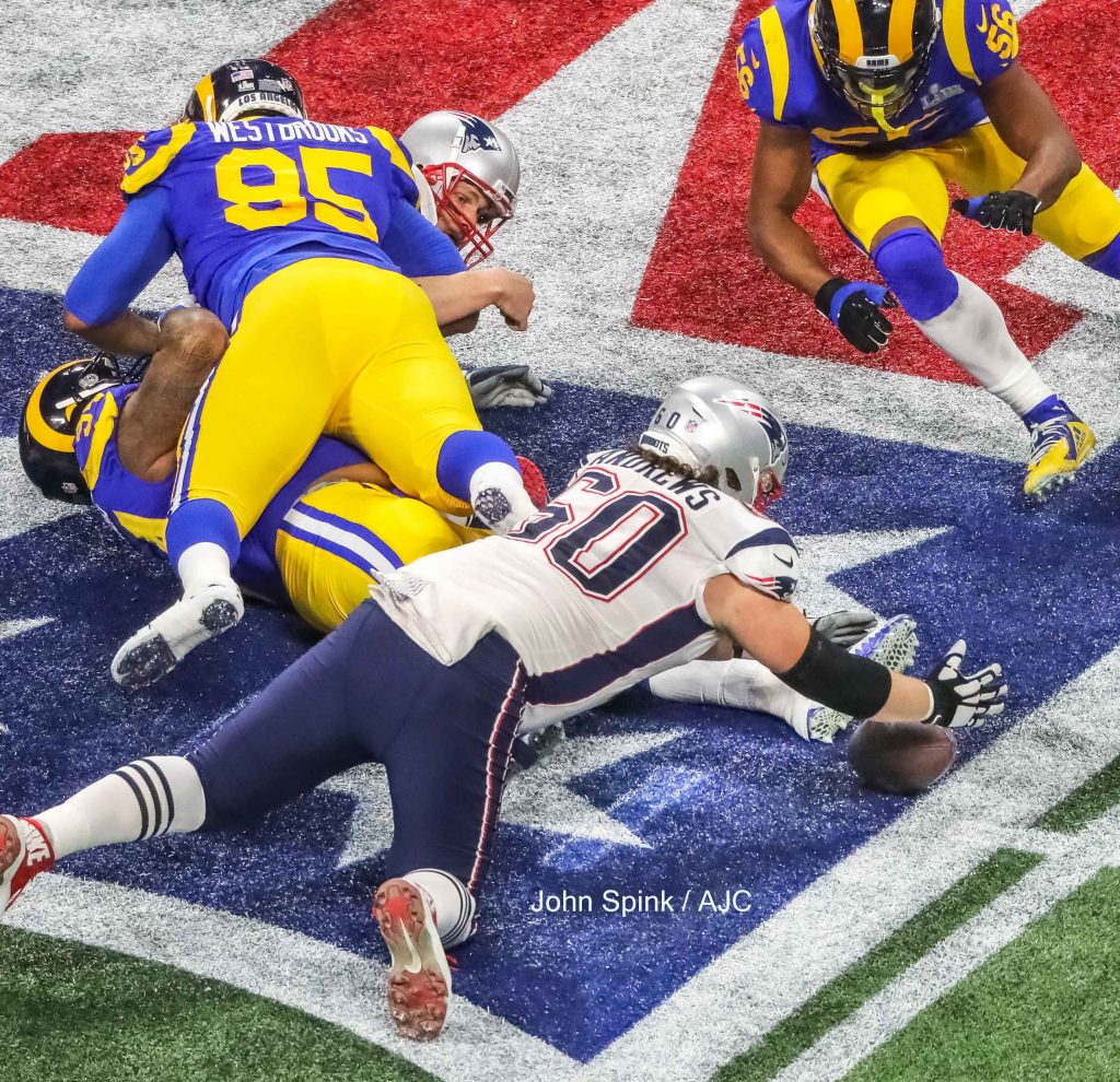 John Spink/Atlanta Journal-Constitution - Los Angeles Rams defensive end John Franklin-Myers (94) and Los Angeles Rams defensive tackle Ethan Westbrooks (95) pile on New England Patriots quarterback Tom Brady (12) (left) after he fumbles the ball while New England Patriots center David Andrews (60) dives on it (below) as Los Angeles Rams linebacker Dante Fowler (56) (right) moves in during 1st quarter action.