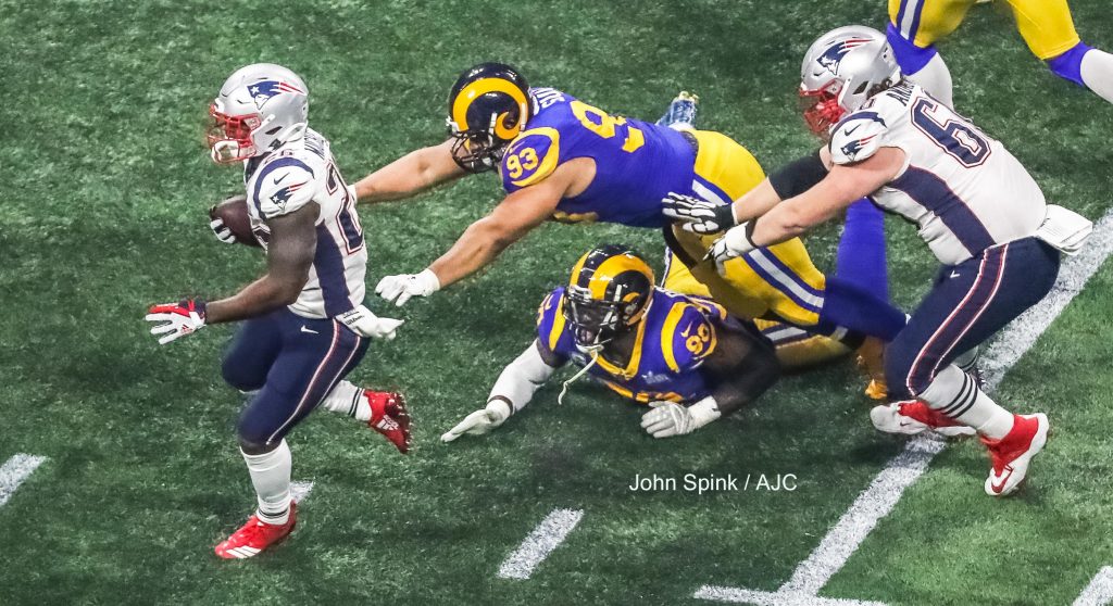 John Spink/Atlanta Journal-Constitution - New England Patriots running back Sony Michel (26) (left) passes by Los Angeles Rams nose tackle Ndamukong Suh (93) and Los Angeles Rams defensive end Michael Brockers (90)(center) as New England Patriots center David Andrews (60)(right) looks on during 3rd quarter play.