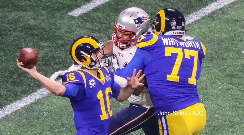 John Spink/Atlanta Journal-Constitution - Los Angeles Rams quarterback Jared Goff (16)(left) releases a pass as New England Patriots defensive end Adrian Clayborn (94) closes in while Los Angeles Rams offensive tackle Andrew Whitworth (77) during 3rd quarter play.